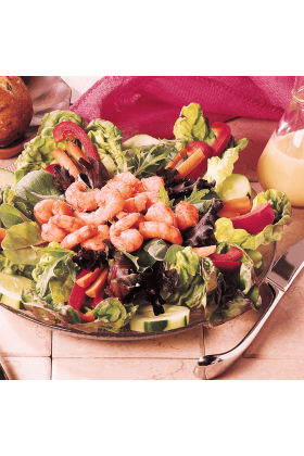 A pile of freshly cooked wild pink shrimp, on a green salad